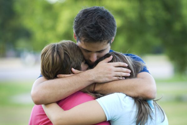 Dad hugging his two children close.